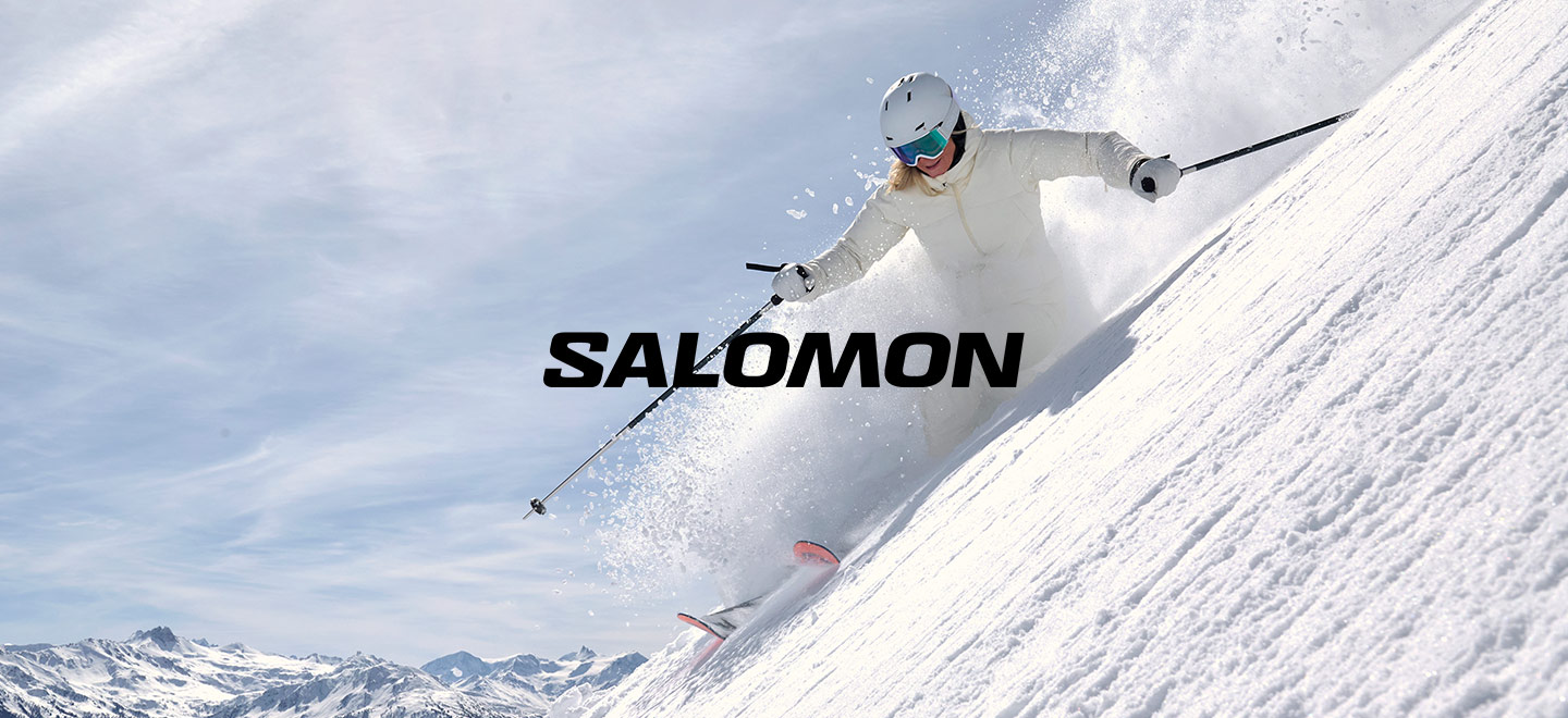 skier in Salomon gear skiing down a slope with the Salomon logo in the middle